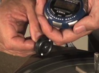 Using a stopwatch to time how long a wheel will spin with different nail finishes.